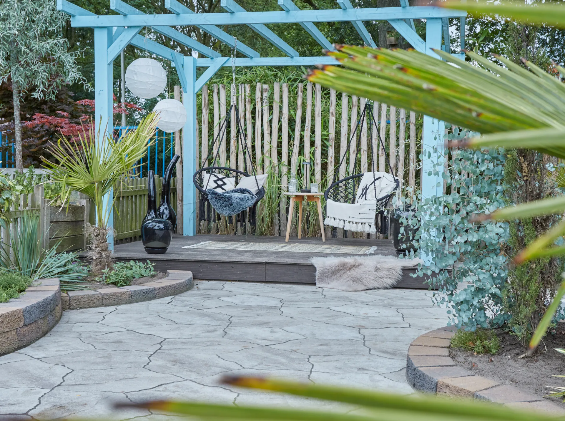 Pergola met hangstoelen en vlonder van composiet