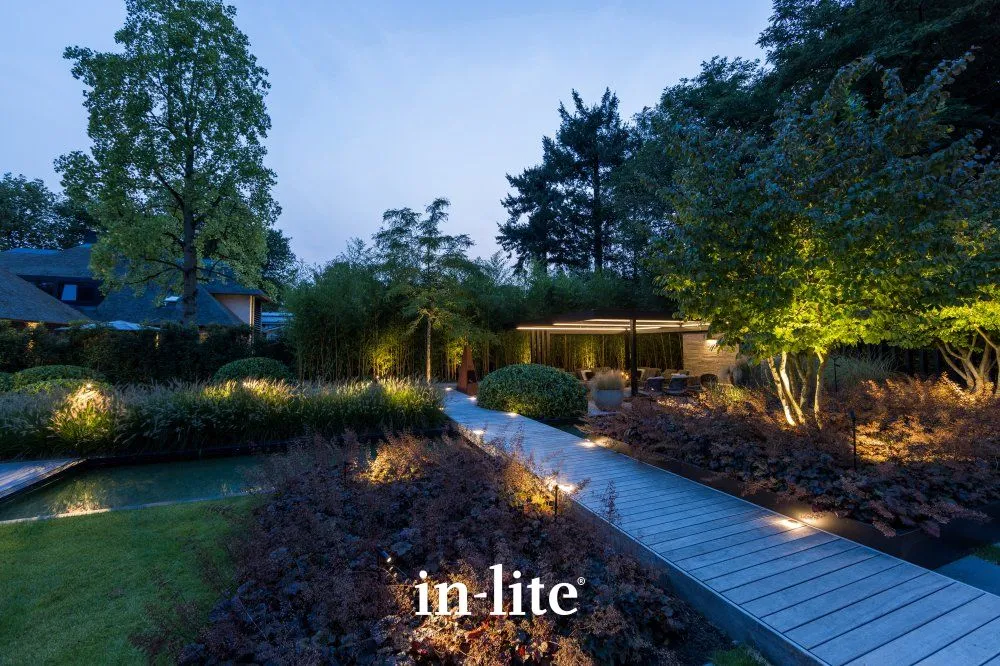 Inlite tuinverlichting langs een vlonder en tussen de beplanting