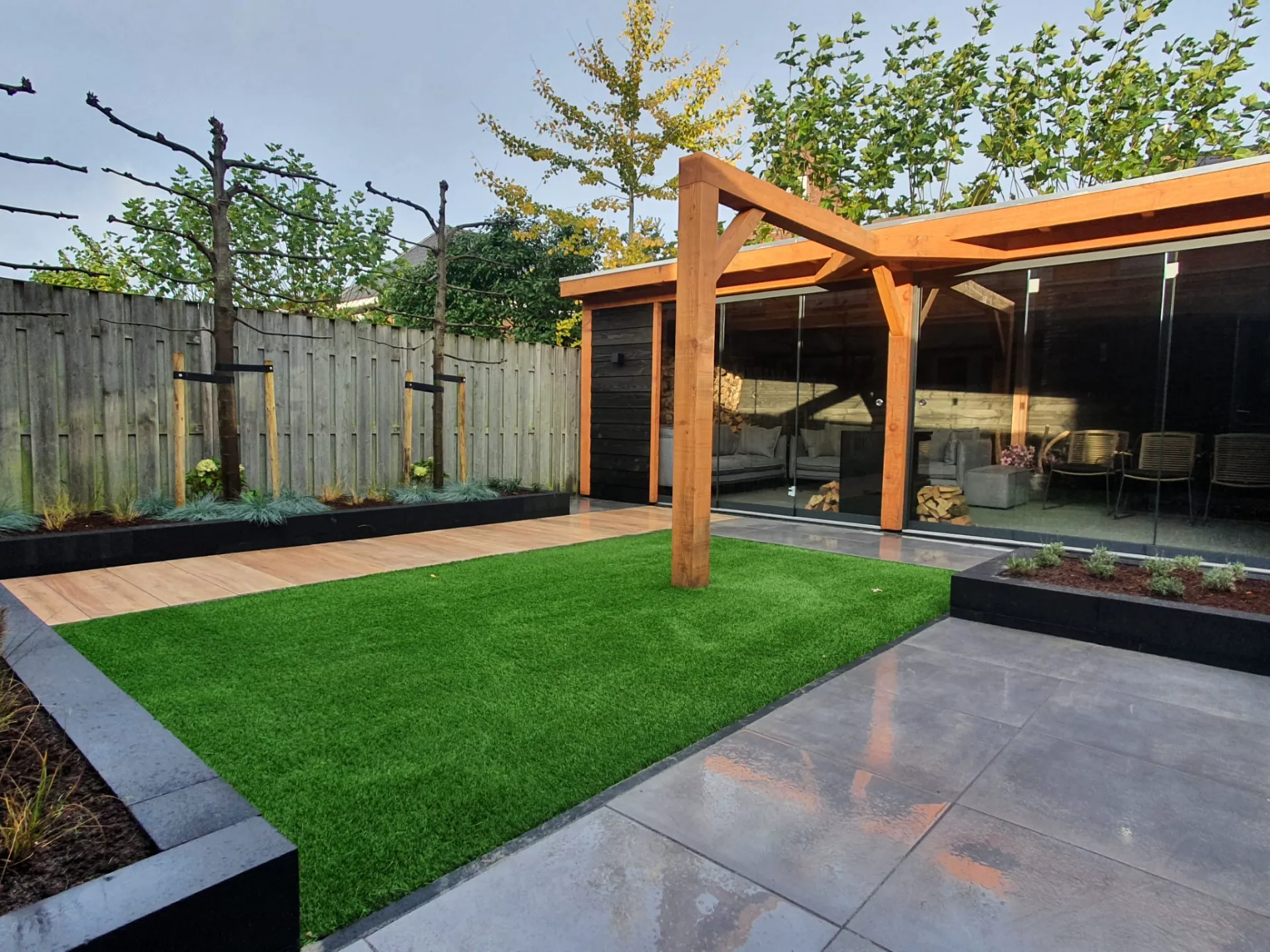 Kunstgras in een moderne tuin met houten overkapping